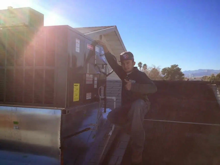 HVAC technician performing HVAC Inspection on a rooftop unit in Prairieville